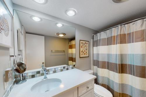 a bathroom with a sink and a toilet and a mirror at Harbour Town Club Villas 1253 in Hilton Head Island