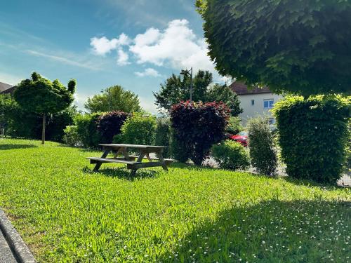 a picnic table sitting in the grass in a park at Charmant studio avec parking in Eguisheim