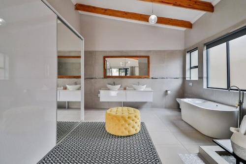 House of Bongekile 4 Bed Luxury Home in Malelane في ماليلين: حمام مع حوض ومغسلة