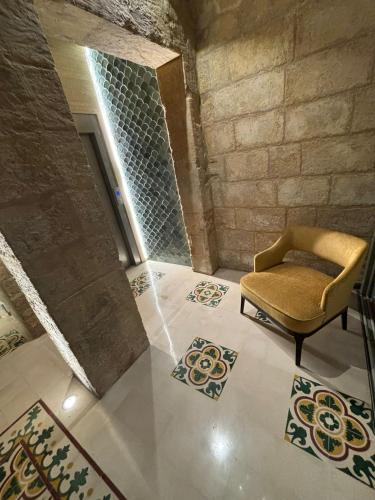 a room with a chair and rugs on the floor at Battery House in Valletta