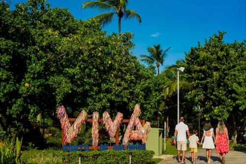 a group of people walking past a sign that says wow at Vivá Porto de Galinhas Resort in Porto De Galinhas
