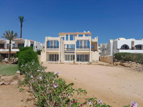 een huis op het strand met bloemen op de voorgrond bij Luxury Sea-view 2 bedrooms apartment in Hadaba in Sharm El Sheikh