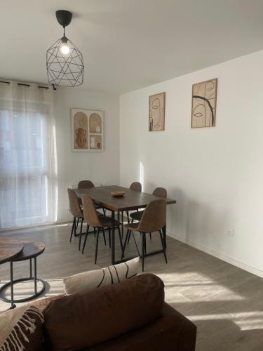 un salon avec une table et des chaises de salle à manger dans l'établissement Appartement cosy proche Paris, à Bezons