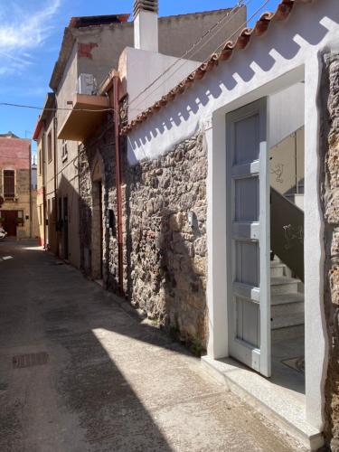 un edificio con una porta sul lato di una strada di Wellhouse a SantʼAntìoco