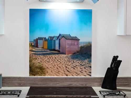 a painting of beach huts on the beach at Mary Bowes Terrace in Bournemouth