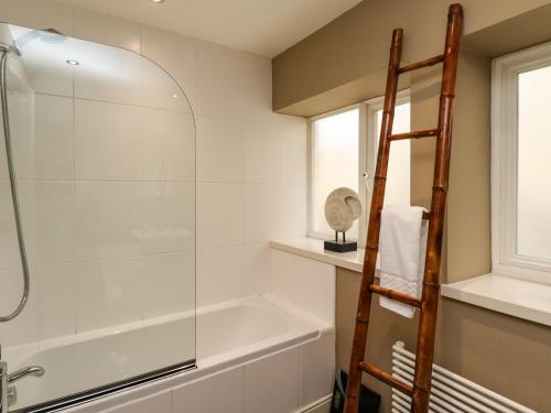 a bathroom with a shower and a tub and a window at The Book House in Warkworth