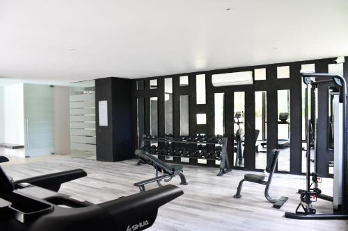 a gym with several treadmills and a person in the background at IIK Tulum Luxury Condo by Spot Rentals in Tulum