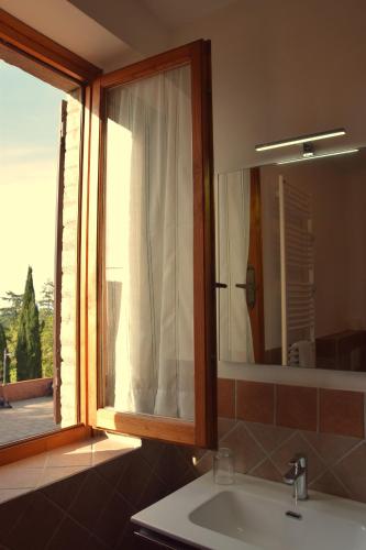 a bathroom with a sink and a mirror and a window at Agriturismo Le Case di San Vivaldo in Montaione