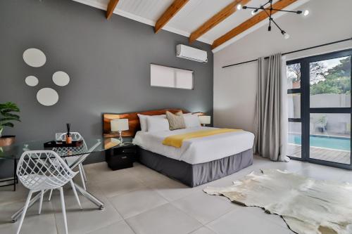 House of Bongekile 4 Bed Luxury Home in Malelane في ماليلين: غرفة نوم مع سرير ومكتب