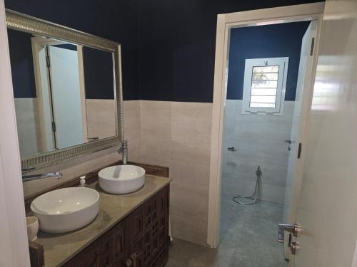 a bathroom with two sinks and a mirror at Premium farmhouse with pool in Rabat
