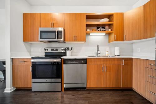 a kitchen with a stove and a microwave at Downtown Birdseye View AC 85" TV Balcony in Traverse City