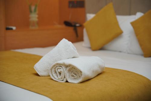 a pile of towels sitting on top of a bed at MyHotel Erbil in Erbil