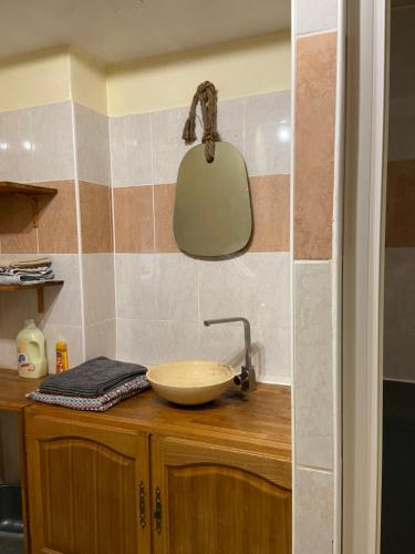 - un comptoir de cuisine avec un évier et un miroir dans l'établissement Appartement 3 pièces RDC plein centre ville, à Marciac