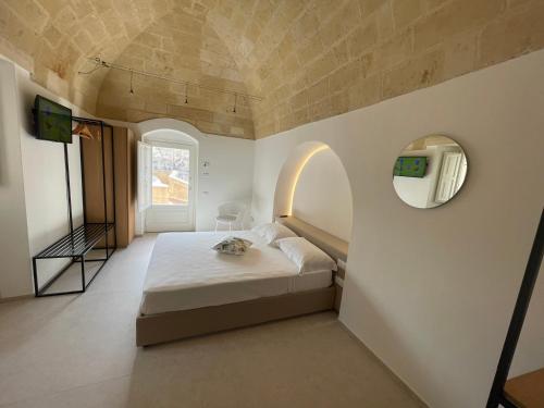 a bedroom with a bed and a mirror on the wall at Giardini di Luce in Matera