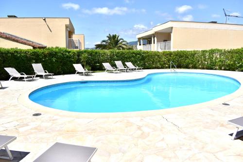 une piscine avec des chaises et une maison dans l'établissement Magnifique Appartement 2 pièces au calme, à Cannes