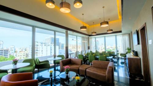 a waiting room with tables and chairs and windows at Holiday Inn Santo Domingo by IHG in Santo Domingo