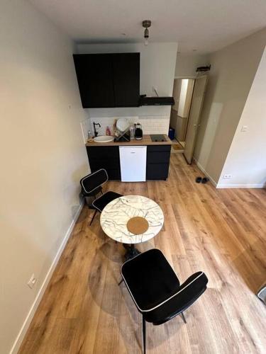 Cette chambre dispose d'une table, de chaises et d'un bureau. dans l'établissement Studio au cœur de la Ville fortifiée, à Boulogne-sur-Mer