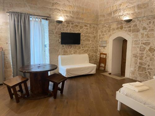 a living room with a table and a white chair at ALTANA DI TUFO in Molfetta