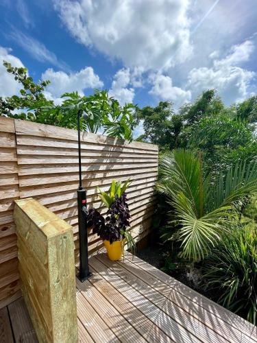 a wooden deck with plants on a fence at La Papaye d’Or in Saint-François