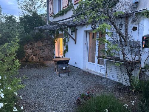 una pequeña casa blanca con mesa y silla en Appartement dans résidence calme dans les Monts du Lyonnais en Soucieu-en-Jarrest