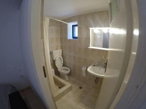 a bathroom with a toilet and a sink at Kalamitsi House 1 in Agia Pelagia