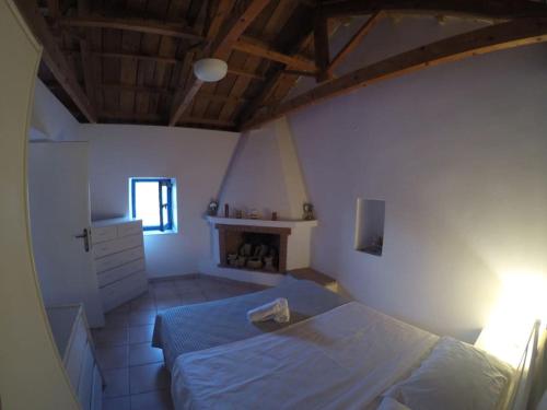 a bedroom with a bed and a fireplace at Kalamitsi House 1 in Agia Pelagia
