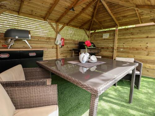 a table and chairs in a cabin with a television at Holmside in Market Drayton