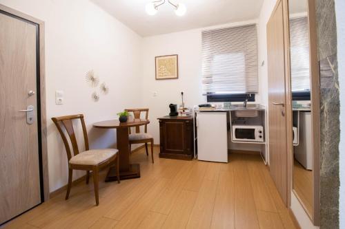 a kitchen with a table and a small table with chairs at 1951 Suites in Kalabaka