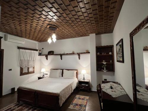 a bedroom with a large bed with a wooden ceiling at Hotel Kaceli in Berat