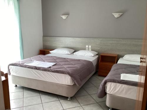 1 dormitorio con 2 camas y ventana en Alexandros, en Kamena Vourla