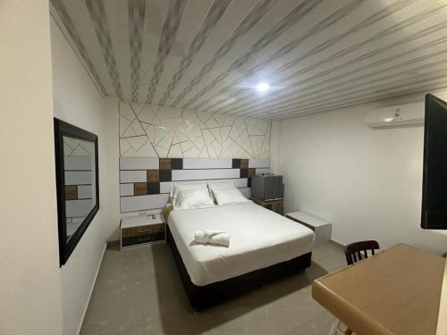 a bedroom with a bed and a table and a desk at Hotel Real De Minas in El Paso