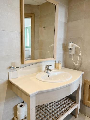 a bathroom with a sink and a mirror at Alona Luxury Villas in Arkasa