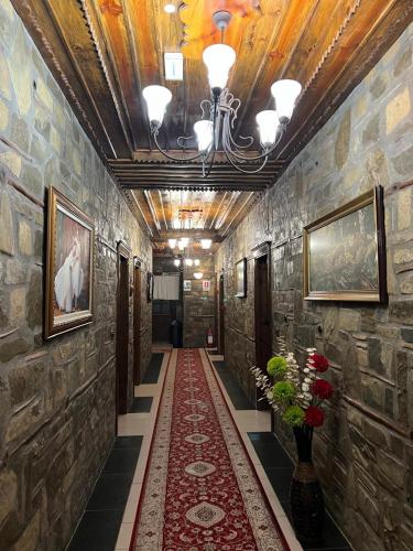 a hallway with stone walls and a red carpet at Hotel Kaceli in Berat