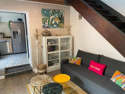 a living room with a couch and a kitchen at Maison Capbreton à 4 min des plages in Capbreton