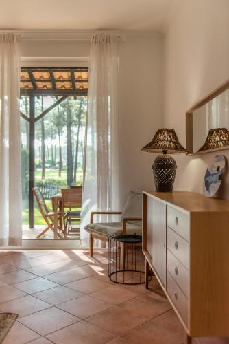 a living room with a dresser with a lamp on it at Sun & Sea Golf House in Aroeira