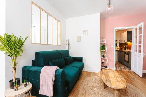 un salon avec un canapé vert et une table dans l'établissement Le pimpé Rochelais, à La Rochelle