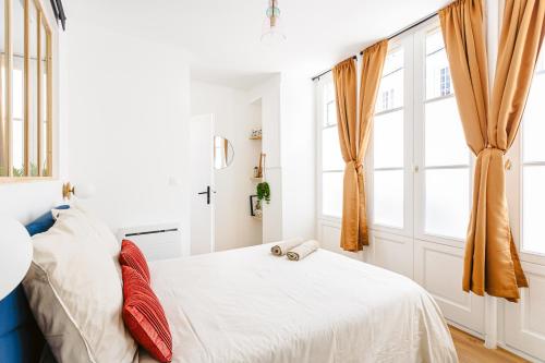 une chambre avec un lit avec des rideaux orange dans l'établissement Le pimpé Rochelais, à La Rochelle