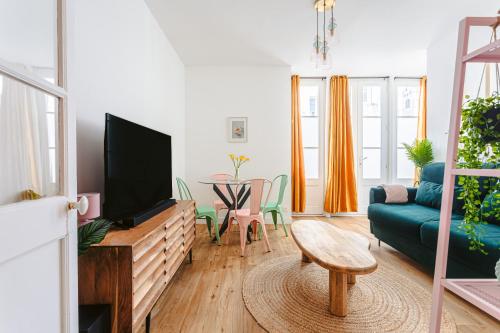 un salon avec une télévision, un canapé et une table dans l'établissement Le pimpé Rochelais, à La Rochelle
