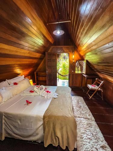two beds in a room with wooden ceilings at Chez Max Pousada in Morro de São Paulo