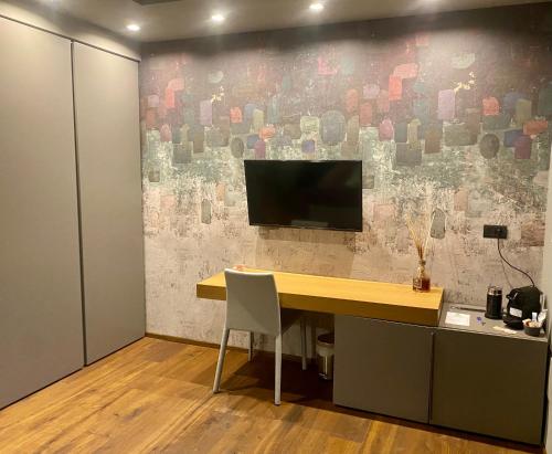 biuro z biurkiem i telewizorem na ścianie w obiekcie Fiorini Rooms Pescasseroli w mieście Pescasseroli