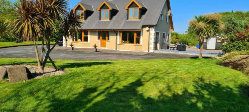a house with a palm tree in front of it at castle Road House in Castletownbere