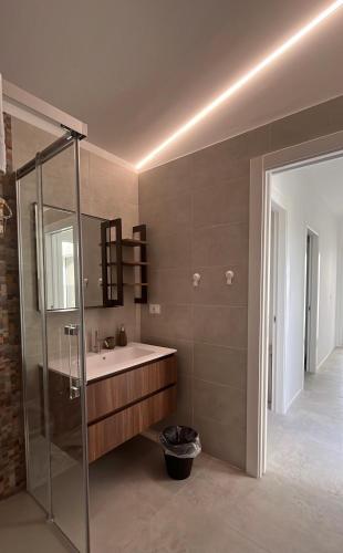 a bathroom with a sink and a glass shower at I Secolari di Giulia in Avola