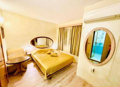 ein Hotelzimmer mit einem Bett und einem Spiegel in der Unterkunft Hotel Color in Warna