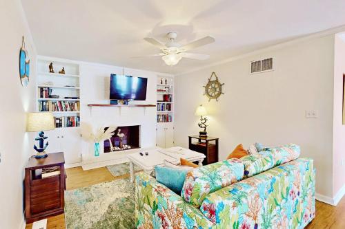 a living room with a couch and a tv at Lorraine's Beach Cottage in Kure Beach
