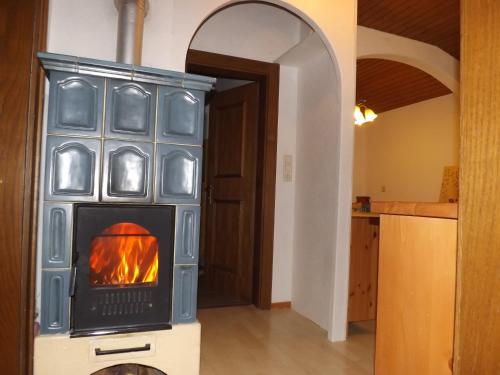 a wood burning stove in a room with a hallway at Haus Enzian in Mittersill