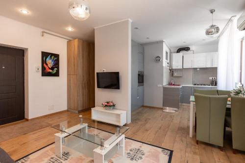 a living room with a glass table and a kitchen at Salt Orchid Central in Turda