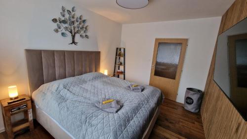 a bedroom with a bed with a blue comforter at Lesíček in Smokovce