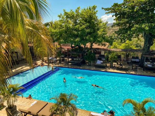 a group of people swimming in a large swimming pool at Hotel Mariscal Robledo in Santa Fe de Antioquia