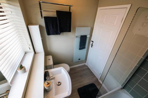 a bathroom with a sink and a toilet and a shower at THE COSY HOME BY KS - Free Parking, WI-FI, Smart TV, Kitchen, Washing machine, Long Stays Welcomed in Hereford