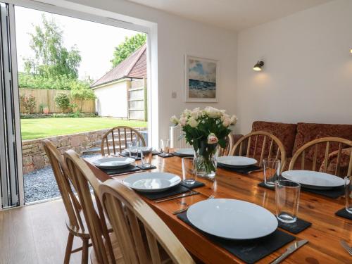 a dining room with a wooden table and chairs at Wendy's Cottage in Minehead